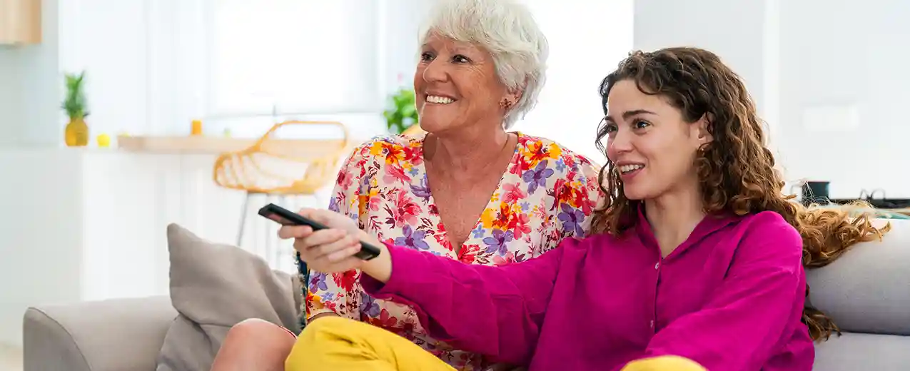 Watching digitized photos on TV Mother and daughter using TV remote control